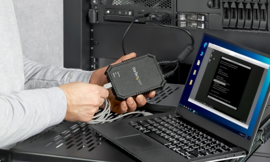 Close up of a crash cart adapter plugged into a server and a laptop